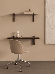 an office chair sitting in front of a desk with a shelf above it and a vase on the table