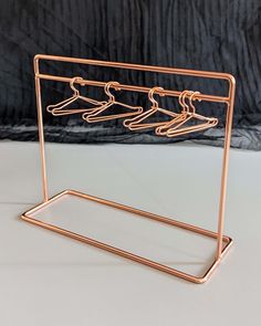 a metal rack with clothes hanging from it's sides and two hangers on each side