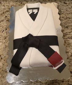 a cake that is shaped like a karate outfit and has a black belt on it