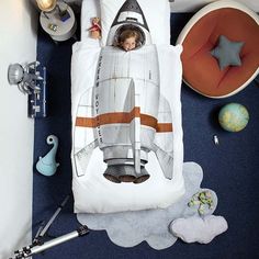 a child's bed with a rocket ship on it