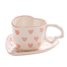 a cup and saucer with hearts on it