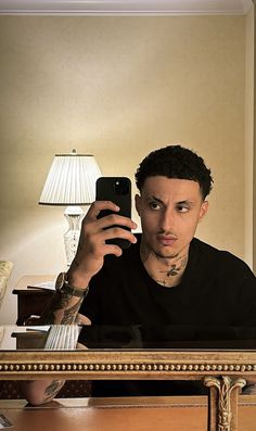 a man taking a selfie in front of a mirror with his cell phone up to his ear