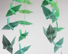 some green origami birds hanging from strings