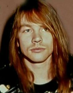 a man with long red hair wearing a black shirt