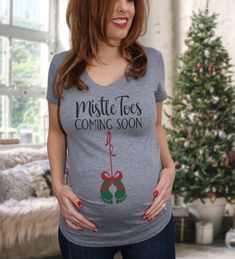 "*SHIPS OUT NEXT BUSINESS DAY A heather gray women's very soft and comfortable fitted maternity v-neck with the ruched side detail. The shirt will automatically come with \"Mistle Toes coming soon\" print in black with red ribbon and green baby feet print. Perfect maternity shirt to announce your pregnancy this Holiday Season! ---------------------------------------------------------------------------------------------------------------------- WASHING & DRYING- Normal wash and it is best to hang Thanksgiving Pregnancy Shirt, Christmas Maternity Shirt, Thanksgiving Pregnancy Announcement, Christmas Pregnancy Announcement, Pregnant Halloween, Pregnancy Announcement To Husband, Christmas Pregnancy, Fall Maternity, Maternity Shirt