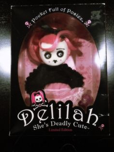 a doll with pink hair and black dress on it's head in a package