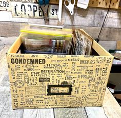 a wooden box filled with lots of stamps and other items on top of a table