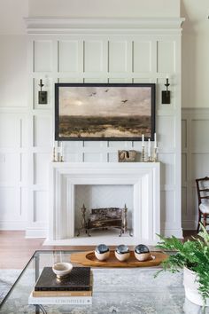 a living room filled with furniture and a fire place in front of a painting on the wall