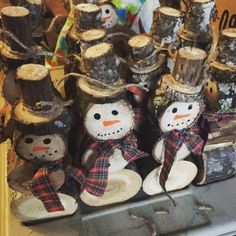 several snowmen made from logs are sitting on a table