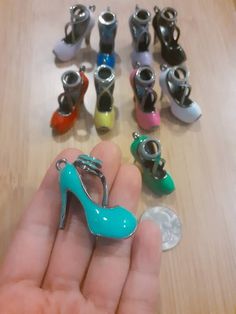 a hand holding a tiny shoe shaped keychain in front of many small shoes