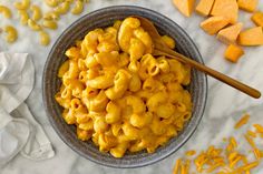 a bowl filled with macaroni and cheese next to sliced pumpkins