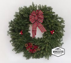 a green wreath with red berries and a bow