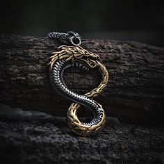 Jormungandr, the World Serpent, epitomizes the fierce tenacity of the fearless Norsemen. This exquisite Jormungandr necklace, a standout piece of Viking jewelry, showcases a finely crafted serpent with its tail coiled over its mouth, perfectly capturing the essence of this legendary creature. More than just an accessory, this Viking necklace is a symbol of the good fortune earned through relentless determination. Wear it to embody the indomitable spirit of the Vikings. Product Details: Pendant H The World Serpent, Serpent Dragon, World Serpent, Gold China, Viking Bracelet, The Vikings, Viking Necklace, Viking Jewelry, Lovely Necklace