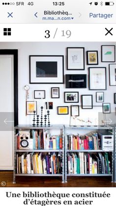 a bookshelf filled with lots of books next to a wall covered in pictures