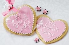 two heart shaped cookies decorated with pink icing