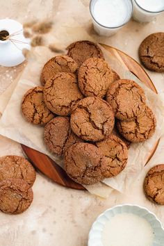 some cookies are on a plate next to milk