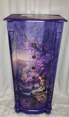 a purple painted dresser with an image of a woman sitting on it