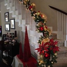 christmas decorations on the banisters and stairs are decorated with red, gold and green ornaments