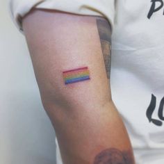 a person with a rainbow tattoo on their arm