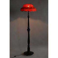 a floor lamp with a red shade on it