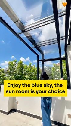 a person standing in front of a window with the words enjoy the blue sky, the sun room is your choice