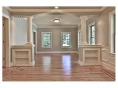 an empty room with wood floors and columns