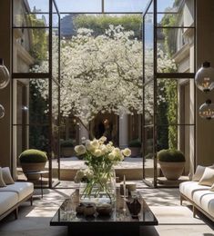 a living room filled with lots of furniture and flowers on top of a coffee table