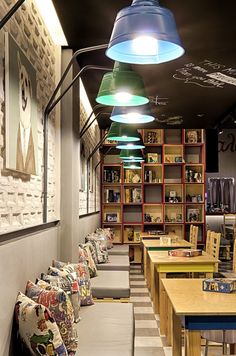 a restaurant with lots of tables and couches in front of bookshelves filled with books