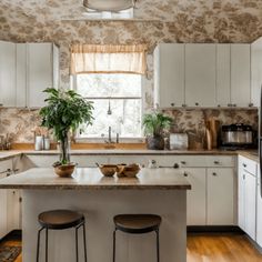 a kitchen with two stools and a center island