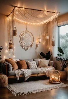 a living room filled with lots of furniture and lights hanging from the ceiling above it