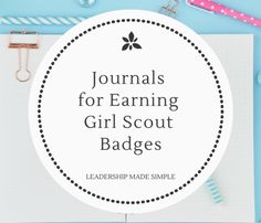 the words journals for earning girl scout badges on top of a clipboard with school supplies