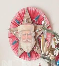 a paper plate with a santa clause on it and a christmas tree in the background