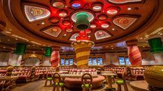 the interior of a fancy restaurant with candy canes on the ceiling and round tables