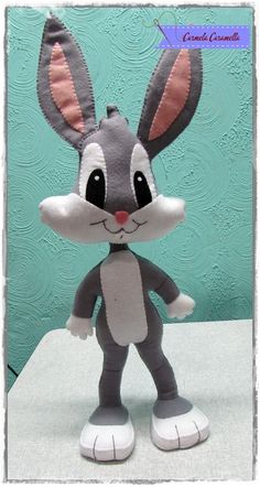 a stuffed animal rabbit is standing on a white surface with a blue wall in the background