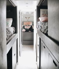 a narrow hallway leading to a bedroom with two beds