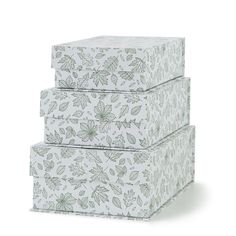 three boxes are stacked on top of each other, with leaves and flowers printed on them