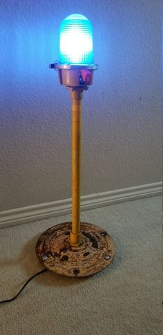 a blue light sitting on top of a wooden pole in the middle of a room