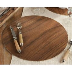 a wooden table with silverware and wine glasses