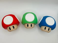 three different colored mushrooms sitting next to each other on top of a white countertop