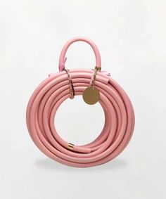 the pink cord is connected to a gold plated metal hook on a white background