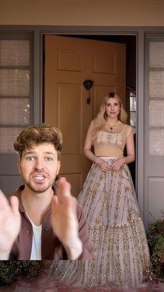 a man and woman standing in front of a door with their hands up to the camera