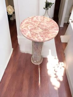 a marble table sitting on top of a hard wood floor