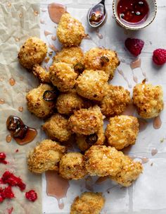 some food is laying out on a table with sauces and berries around it in the foreground