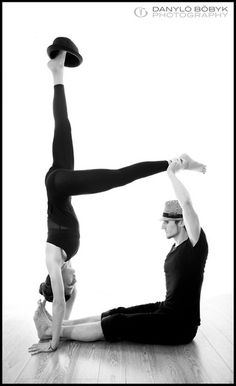 two people are doing acrobatic poses on the floor in black and white