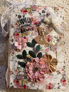 an altered book with flowers and buttons on it