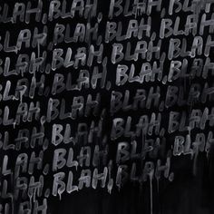 black and white photograph of graffiti written in different languages on a wall with the word'blaah'below it