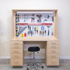 a workbench with lots of tools on it and a stool in front of it