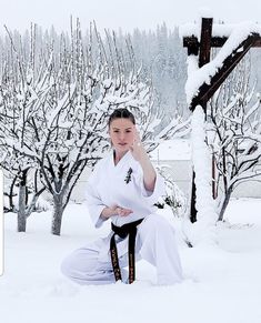 a woman sitting in the snow with her hand on her chin