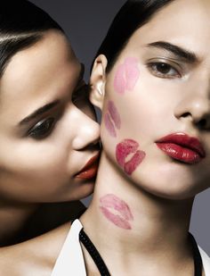 two women with lipstick painted on their faces