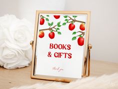 there is a sign that says books and gifts next to a vase with white flowers